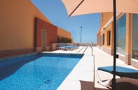 Piscina exterior con solarium y tumbonas. Vistas al mar
